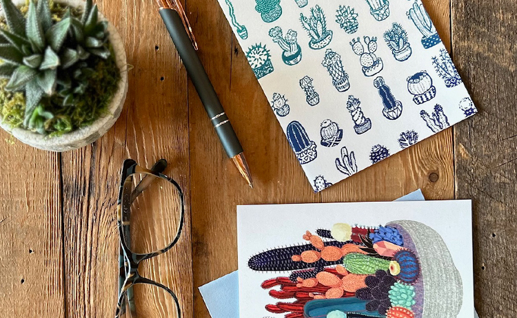 Table with cactus, glasses, pen, and cards